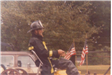 Firefighter Steering a Horse Drawn Cart During a Parade