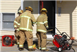 Three Firefighters at the Front Door of the House Fire