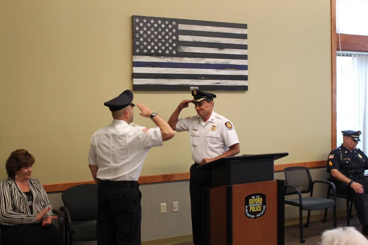 2 police officers saluting eachother