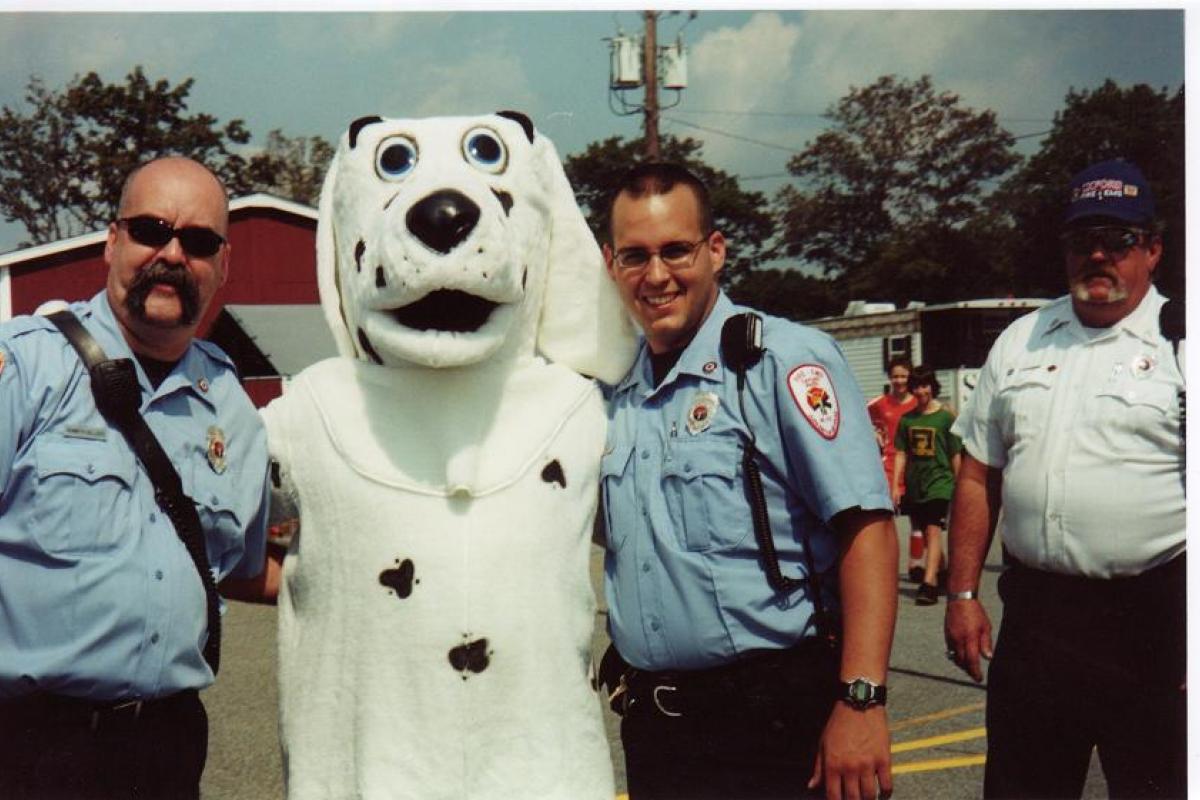 Fire Dalmatian Mascot Character Taking a Photo with Two Fire Employees