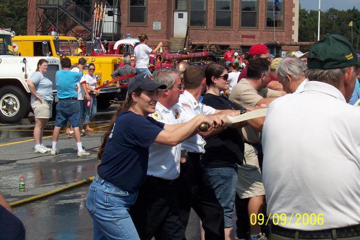 People Manually Pumping Water with an Old Fire Cart