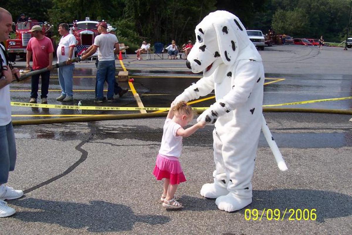 Fire Dalmatian Mascot Character Dancing with a Little Girl 1