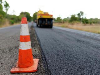 Construction cone next to road being paved